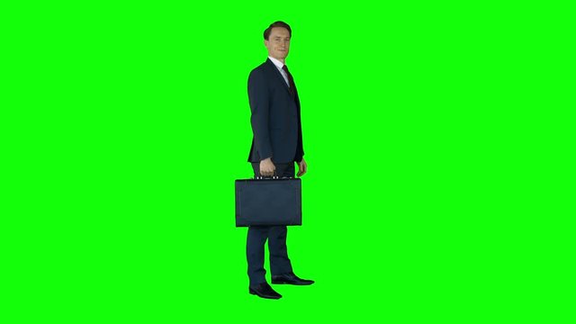 Businessman standing on green screen with suitcase
