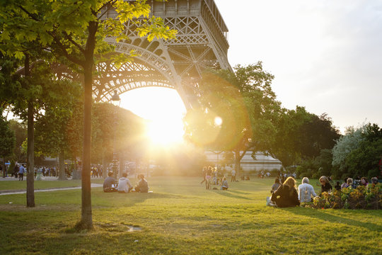 France, Ile-de-France, Paris, People in park by Eiffel Tower at sunset