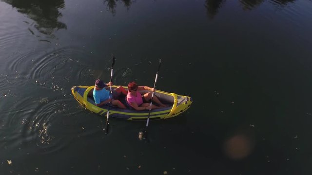 AERIAL: Flying above mature couple kayaking on river