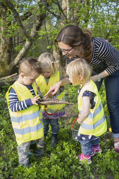 Sweden, Vastergotland, Olofstorp, Bergum, Woman taking care of children (2-3) outdoors