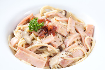 Close up spaghetti carbonara which has mushrooms, ham and black