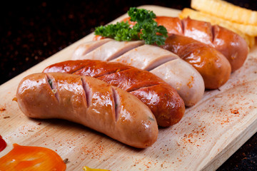 Close up grilled sausage with chili powder and french fries and