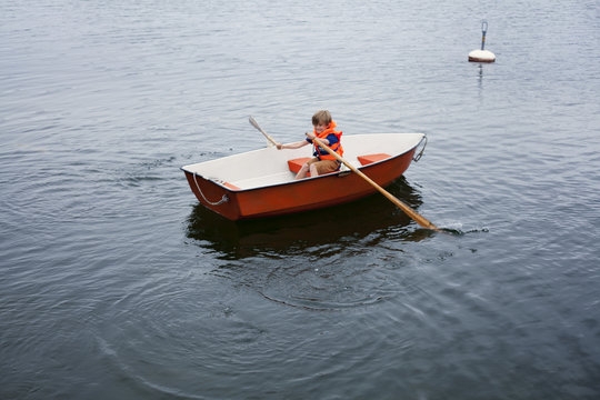 Sweden, Uppland, Runmaro, Barrskar, Boy (6-7) in rowboat