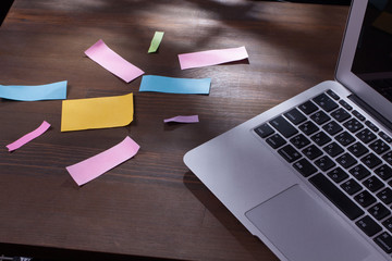 沢山の散らかったポストイットとノートパソコン