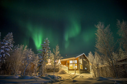 Finland, Lapland, Kittila, Levi, Aurora borealis over cottage