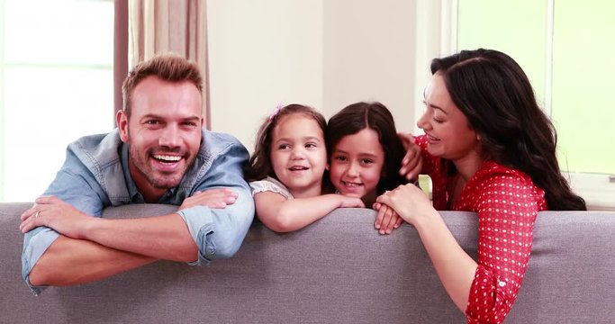 Smiling family posing on sofa 