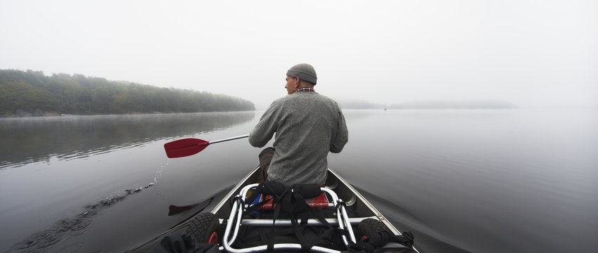 Rear view of man rowing boat in lake