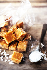 .Salted caramel pieces and sea salt close up. Butter caramel can