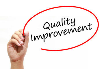 Man Hand writing Quality Improvement with marker on transparent wipe board. Business, internet, technology concept.