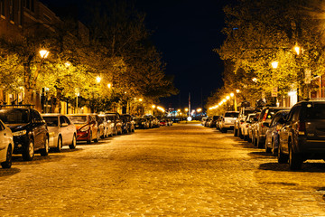 Fototapeta na wymiar Cobblestone street at night, in Fells Point, Baltimore, Maryland