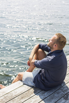 Sweden, Stockholm Archipelago, Grasko, Man sunbathing on jetty