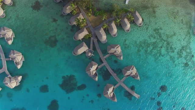 AERIAL: Flying above luxury overwater bungalow villas at hotel resort