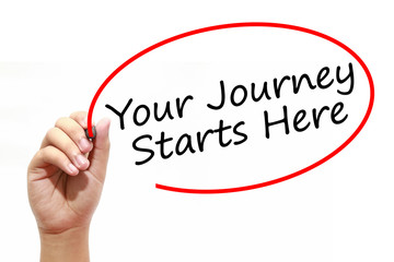 Man Hand writing Your Journey Starts Here with marker on transparent wipe board. Business, internet, technology concept.