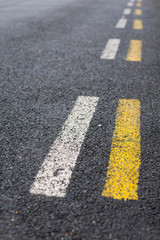Obraz premium Parallel dashed road lines in white and yellow
