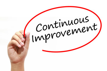 Man Hand writing Continuous Improvement with marker on transparent wipe board. Business, internet, technology concept.