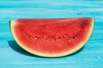 Fototapeta na wymiar Fresh slice of watermelon on blue wooden background