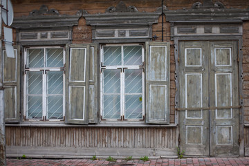 Fototapeta na wymiar Old wooden and weathered town house facade