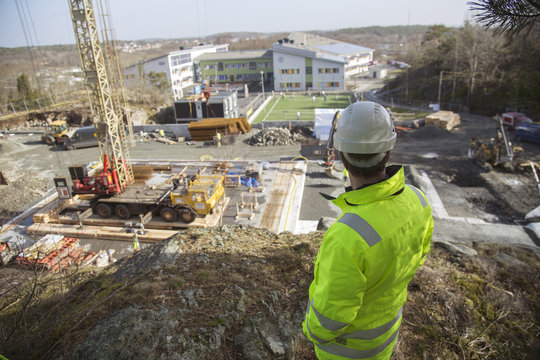 Rear view of worker standing at construction site