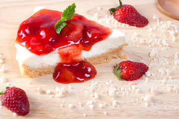Close up strawberry cake on wooden plate on wood table.