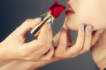 female hands with red rose lipstick