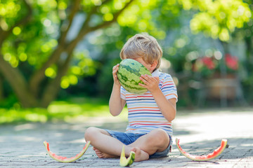 little preschool kid boy eating watermelon in summer