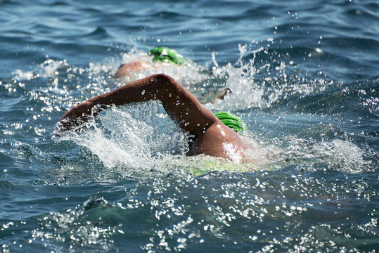 Triathlon swimmers churning up the water two swimmers in races in triathlon