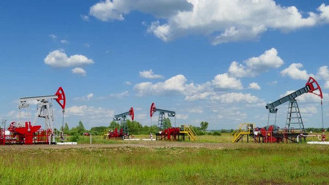 many working oil pumps in a row at sunny day, 4k
