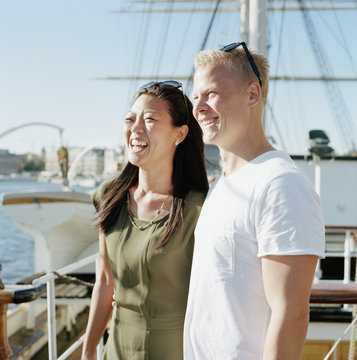 Sweden, Stockholm, Skeppsholmen, Smiling mid-adult couple aboard sailboat