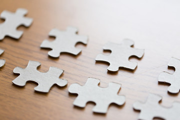 close up of puzzle pieces on wooden surface