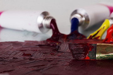 Open tubes of paint mixing with brush