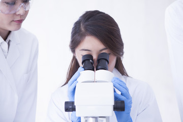 Female researcher looking through a microscope