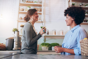 Female employees standing behind juice counter