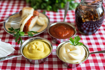 Sausages in dough (Mini hot dog homemade) with ketchup, mayonnaise and parsley on the plate and cola in a glass jar