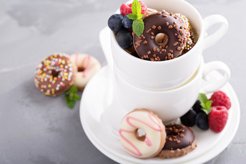 Little colorful donuts in white cup