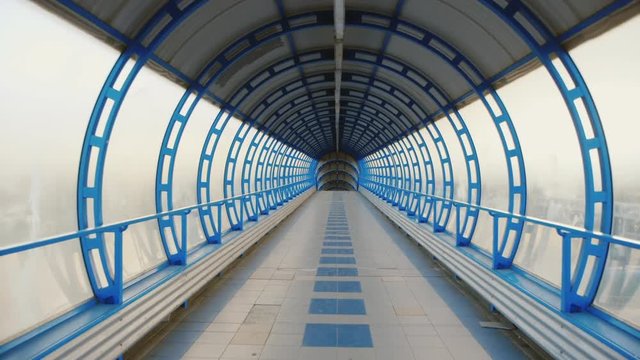 Camera flying through a glass tunnel. The transition between the terminals of the airport or train station. POV video