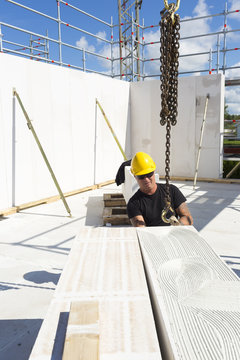 Sweden, Ostergotland, Linkoping, Construction worker preparing building block to be lifted
