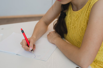 close up of girl's hand with pen doing math, drawing triangle