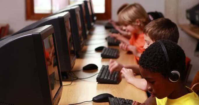 Row of pupils working in computer class in elementary school