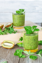 Ingredients for preparation of: kiwi, arugula, mint and two glasses smoothies
