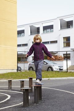 Sweden, Vastra Gotaland, Goteborg, Hisingen, Fargenas, Girl (6-7) walking on wooden posts
