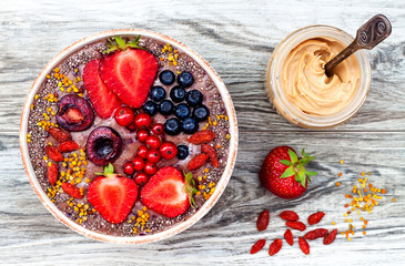 Acai breakfast superfoods smoothies bowl with chia seeds, bee pollen, goji berry toppings and...