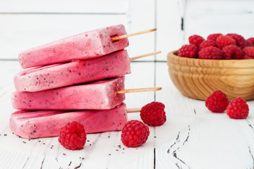 Homemade vegan raspberry coconut milk popsicles - ice pops - paletas with chia seeds on rustic...