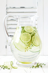 Cucumber infused hydrating water with thyme and lime. Homemade flavored lemonade on rustic old...