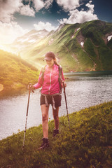 Active fit woman hiking alongside an alpine lake
