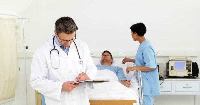 Doctors and nurse watching over sick patient