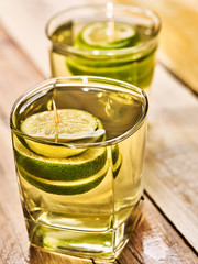 Alcohol drink. On wooden boards are two glasses with alcohol green transparent drink. Drink number hundred and three cocktail green tea with lime. Country life. Light background.
