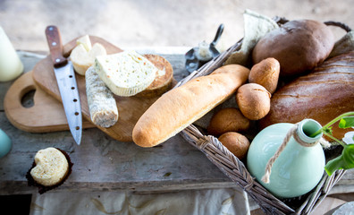 The table on which stands a vase of flowers and a basket of biscuits and bread and cheese