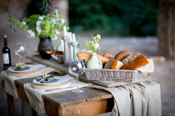 The table on which stands a vase of flowers and a basket of biscuits and bread and cheese
