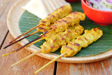 grilled chicken satay with dipping sauce and side dish
