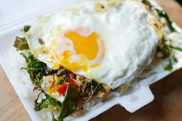 asian food, rice with chicken basil and egg in styrofoam box con